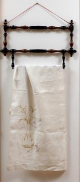 Obešalnik za brisačo, 1889, stružen les; brisača, 1899, laneno platno z ažurom.